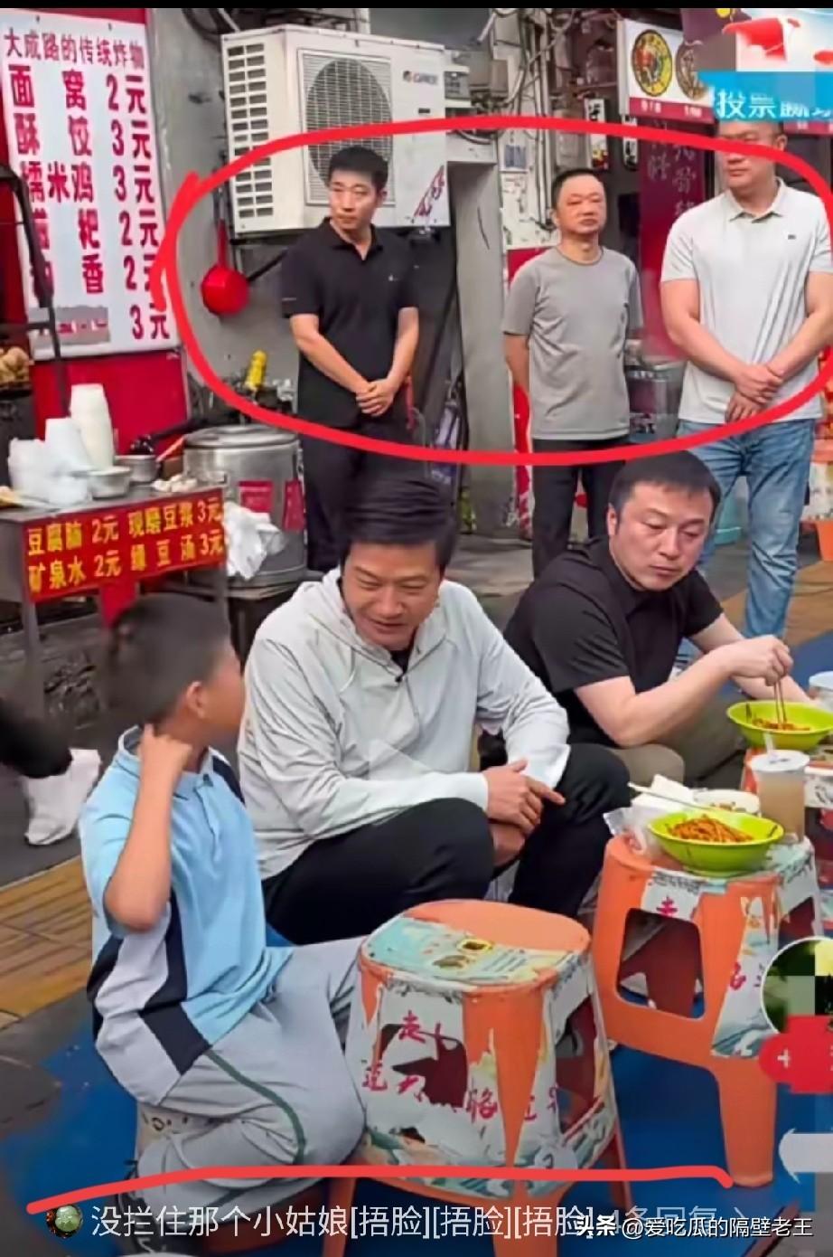 你相信吗？企业家大口吃面，三排西装高管站成圆圈，旁边一个孩子面前，碗是空的。全场
