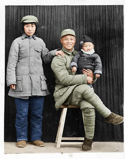 这是1944年延安的一张全家福：晋察冀军区骑兵团团长范昌标坐在木凳上，怀里抱着年