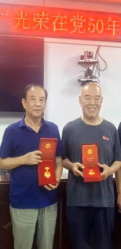 昨天上午，会议室桌上的红绒布托盘里，摆着三枚“光荣在党50年”纪念章。台下，只