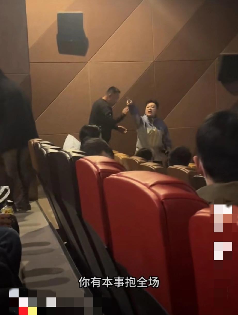 电影院内，后排的短发大姐开着外放玩手机，前排白衣服女士好意提醒让她开静音，这下可