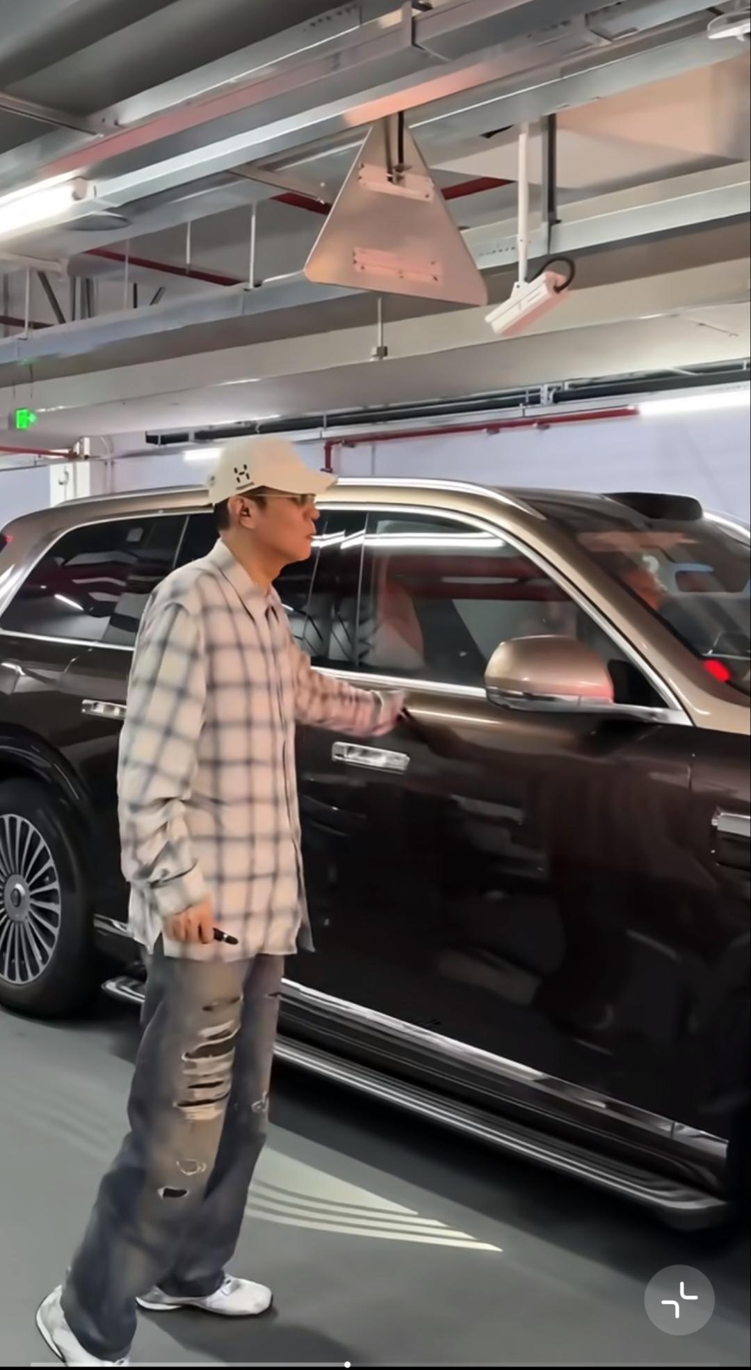 于和伟地下车库下车，灰蓝格纹宽松衬衫配破洞牛仔裤；米白色刺绣棒球帽，戴着墨镜。