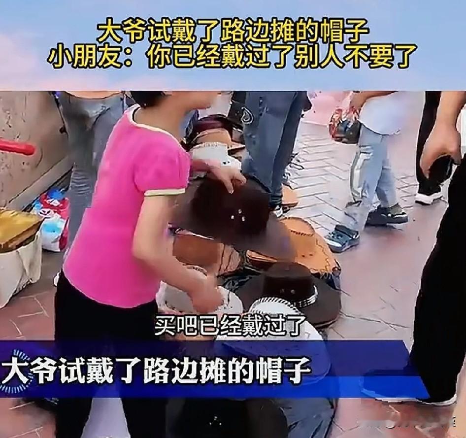 红衣小男孩强买强卖合适吗？路边摊，地上一堆帽子，小男孩正在和一大爷交涉着。