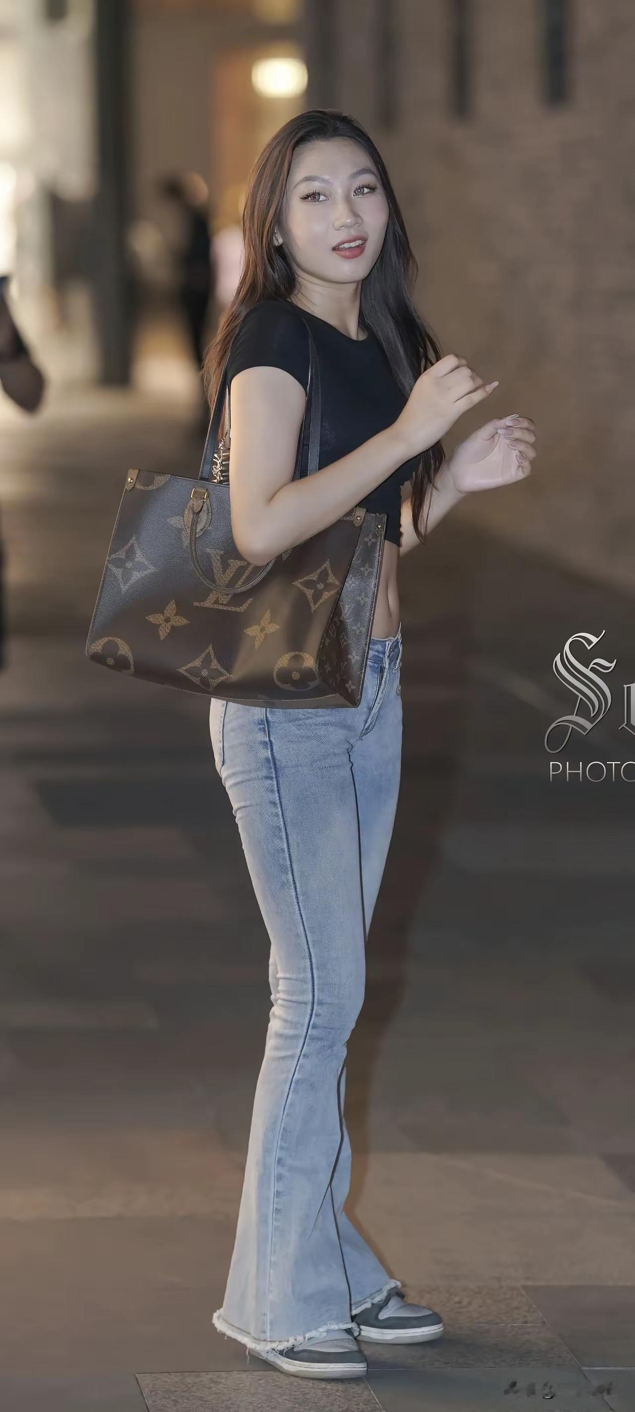 都市时尚少女，手提LV包包，牛仔裤与黑T恤的完美搭配，轻松自在。怎么拍照可以显得