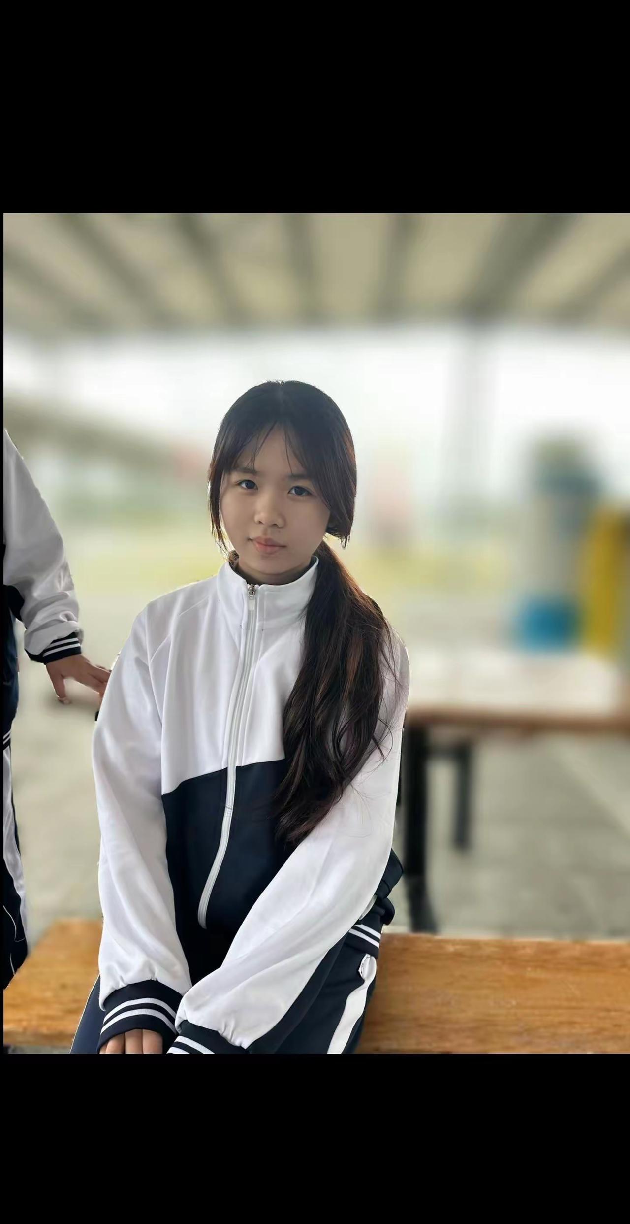 校园日常：青春洋溢的少女在长椅上静坐，背景模糊的校园生活。