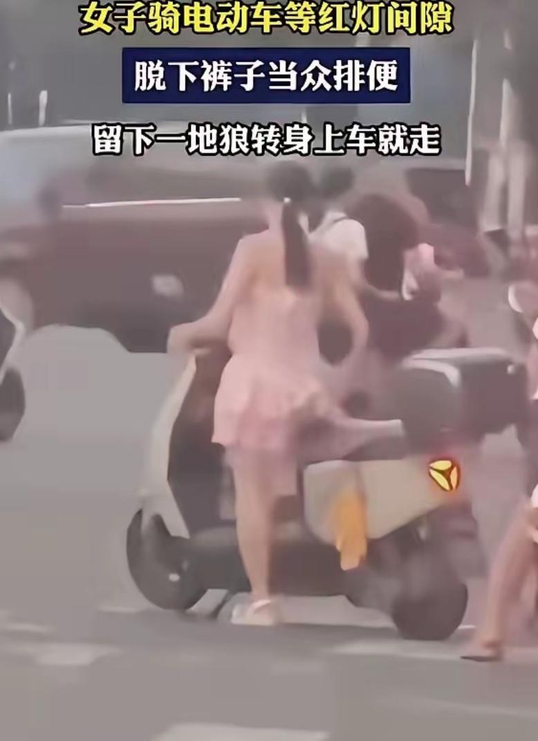 好歹避个人啊！一女子骑电动车等红灯，突然从车上下来，蹲在马路中间，当着前后左右所