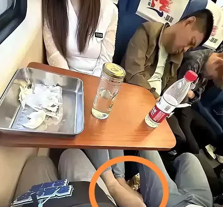 坐过火车的都知道，火车硬座坐久了，腰酸腿疼是常事。可是男子对面的这个女子，有点太