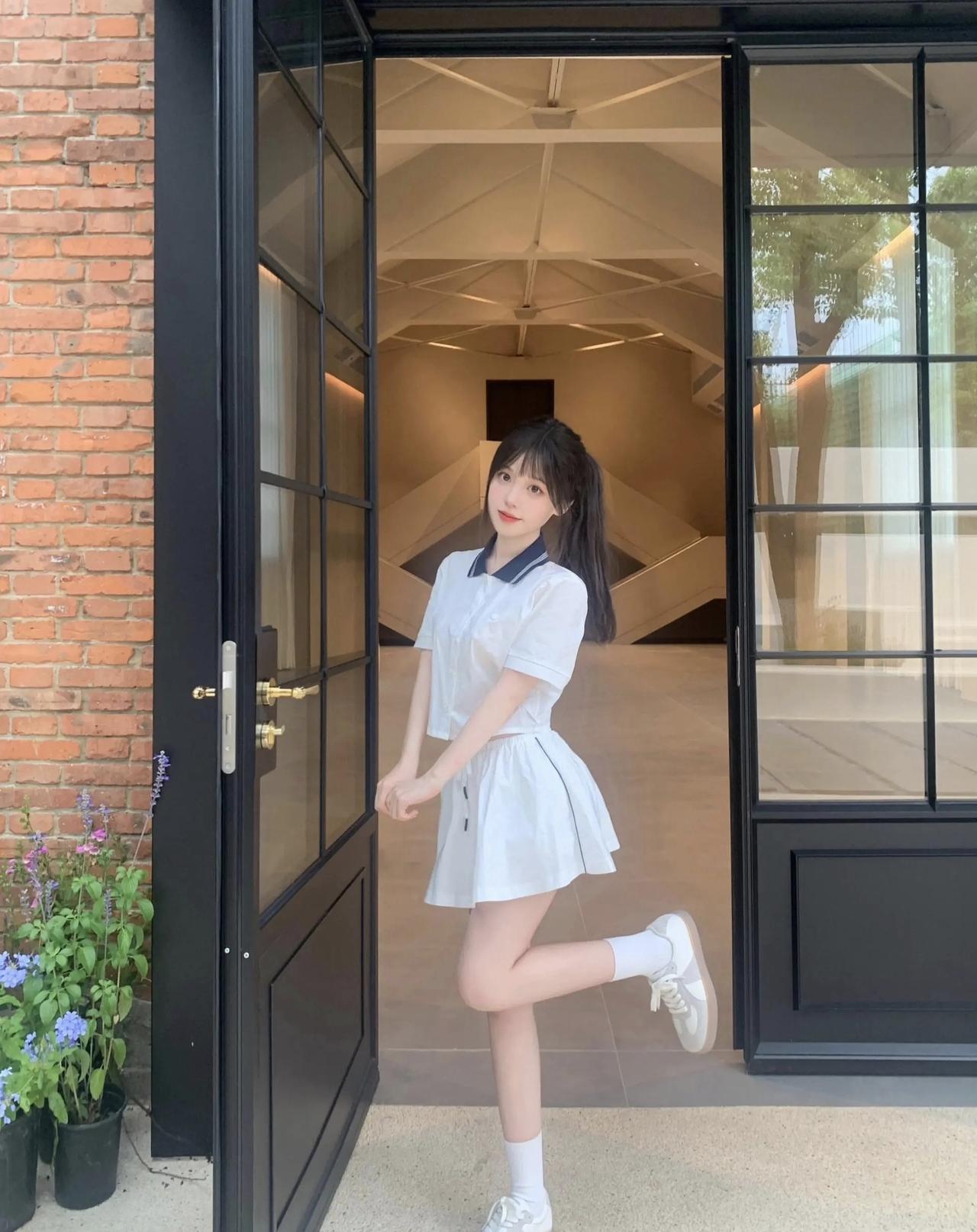 红砖与黑框门撞出的夏日甜妹瞬间，白裙配碎发，把青春的元气焊在身上～