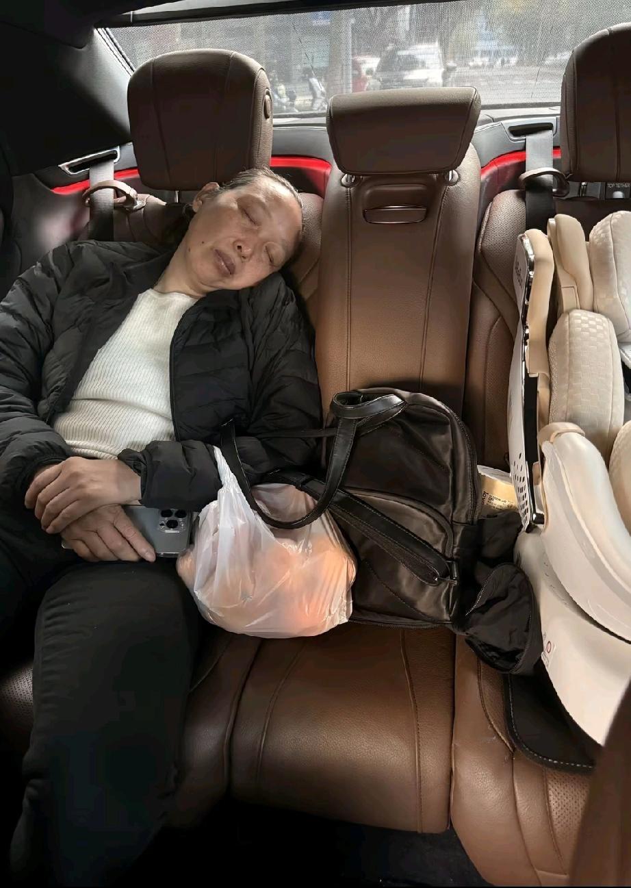 车里是一家人睡觉最踏实的地方，后排还放着洛宝宝的座椅，奶奶坐在另外一边睡着了，她