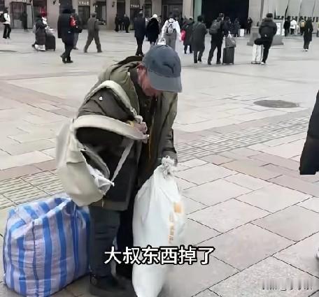 2月5日，北京，一返乡民工大叔走在马路上，背包突然坏了，包里东西掉落一地，一大学