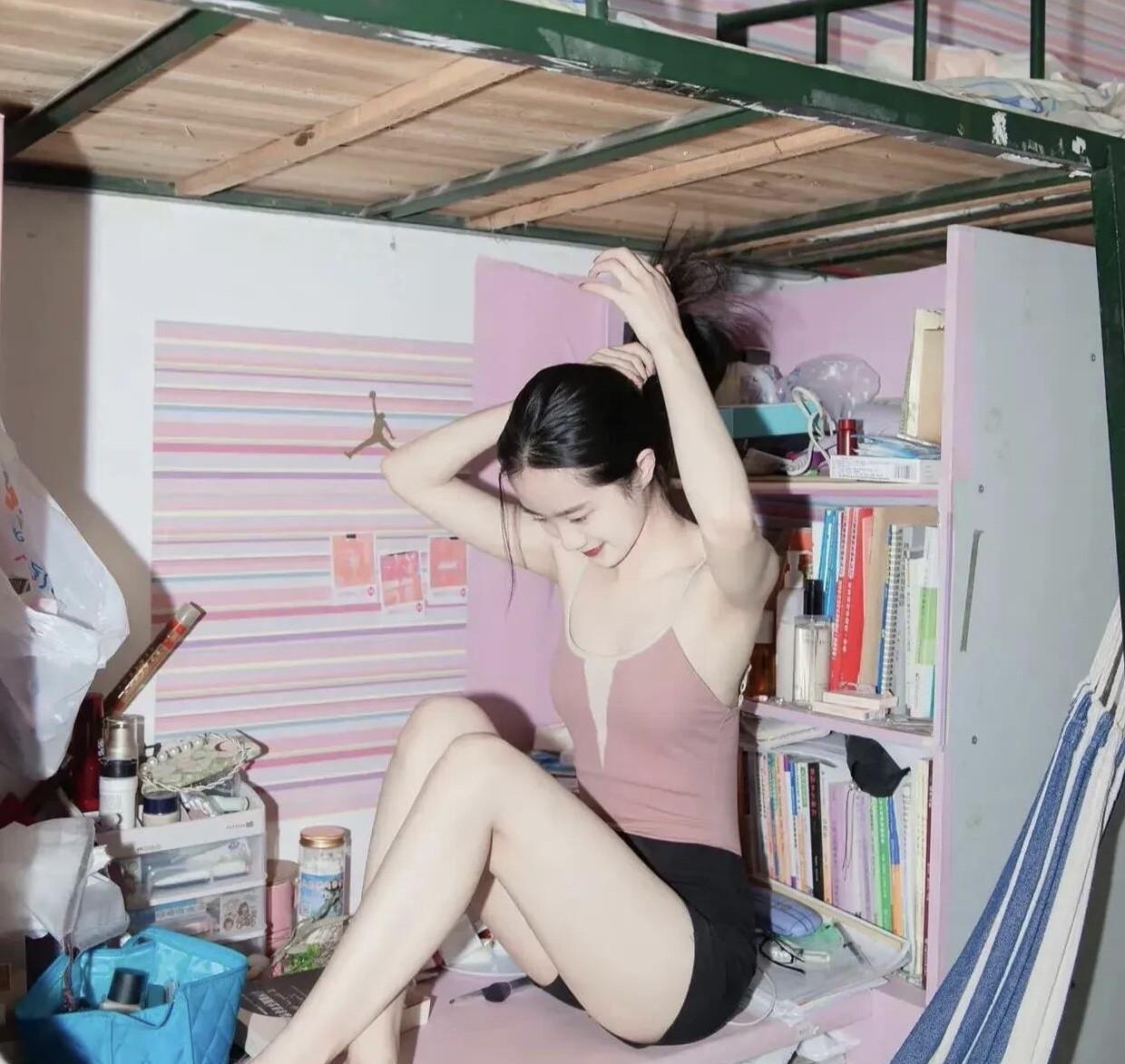 这是一位女大学生在学校宿舍里，同学抓拍的一张照片。当时的她在弄发型，体态优雅，气