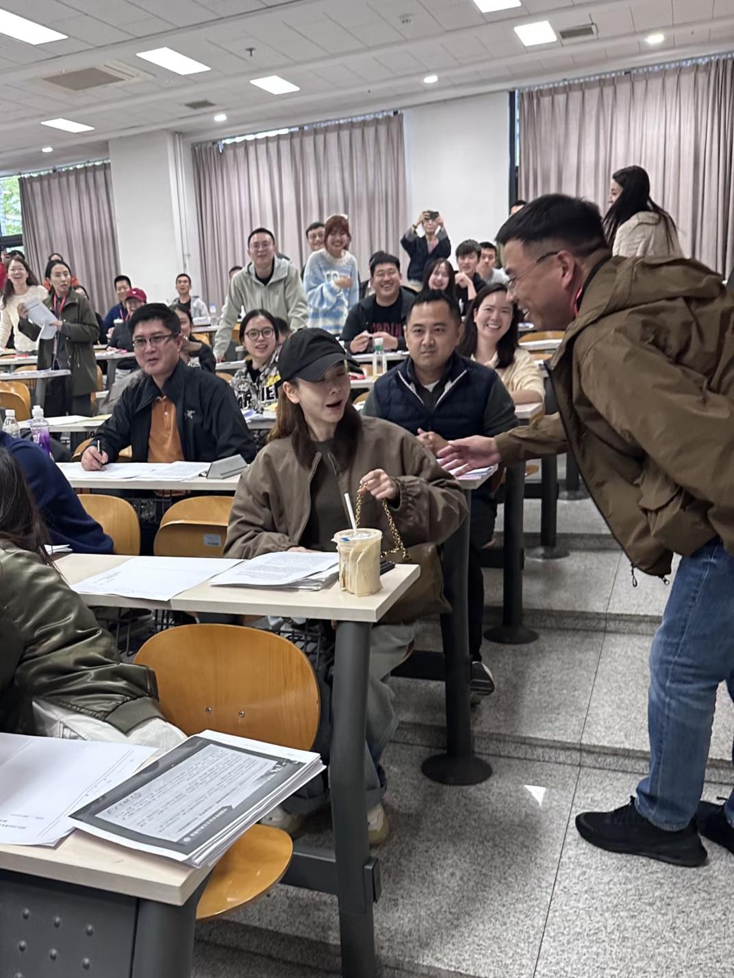 40岁戚薇在北京大学参加考试，她穿着一身日常服饰，像学生一样坐在教室里，桌子上摆