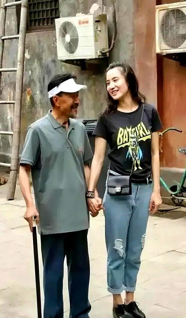 红毯中段。宋佳的高跟鞋突然钉住。她侧身，左手已稳稳托住那位清瘦老者的肘弯——