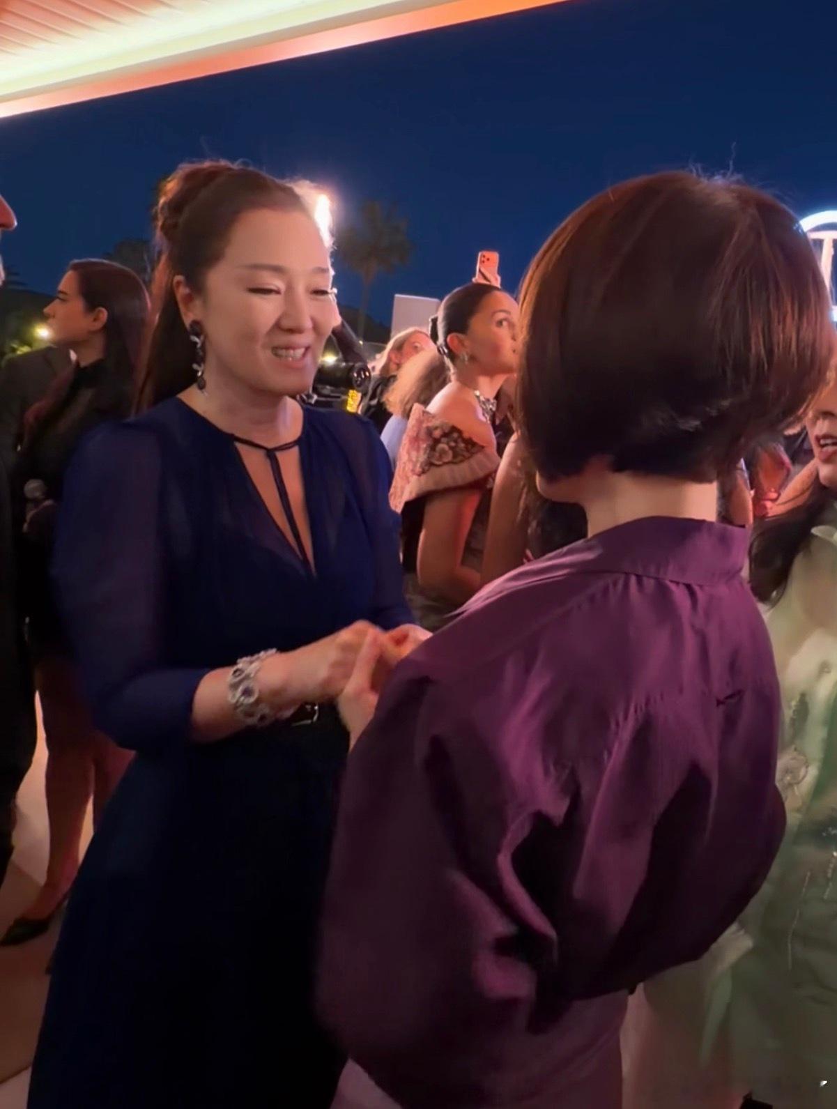 巩俐鲁豫牵手热聊戛纳偶遇同框氛围感拉满，巩俐与鲁豫温柔牵手热聊，气质从容优雅。
