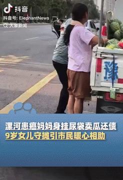 泪目了！河南漯河，一位患癌妈妈带着尿袋，领着小女孩在路边摆摊卖西瓜，为了攒够手术