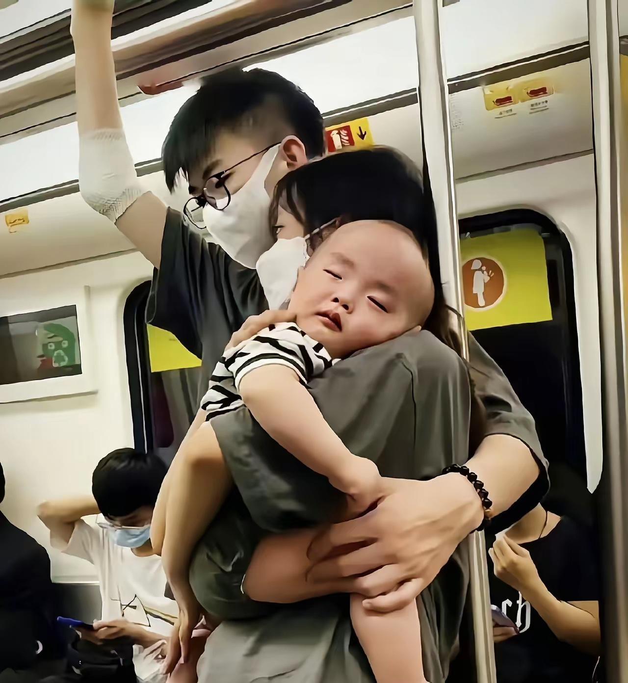 公交车上，一位丈夫张开臂膀，稳稳环着妻子与怀中的孩子。妻子将脸颊轻轻贴在他温热的