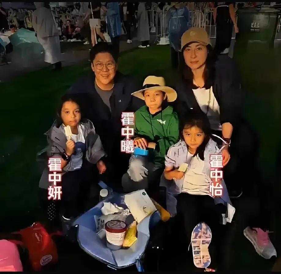 这是郭晶晶一家五口合照。两个女儿分别坐在霍启刚和郭晶晶前面，而他们的儿子坐在夫妻