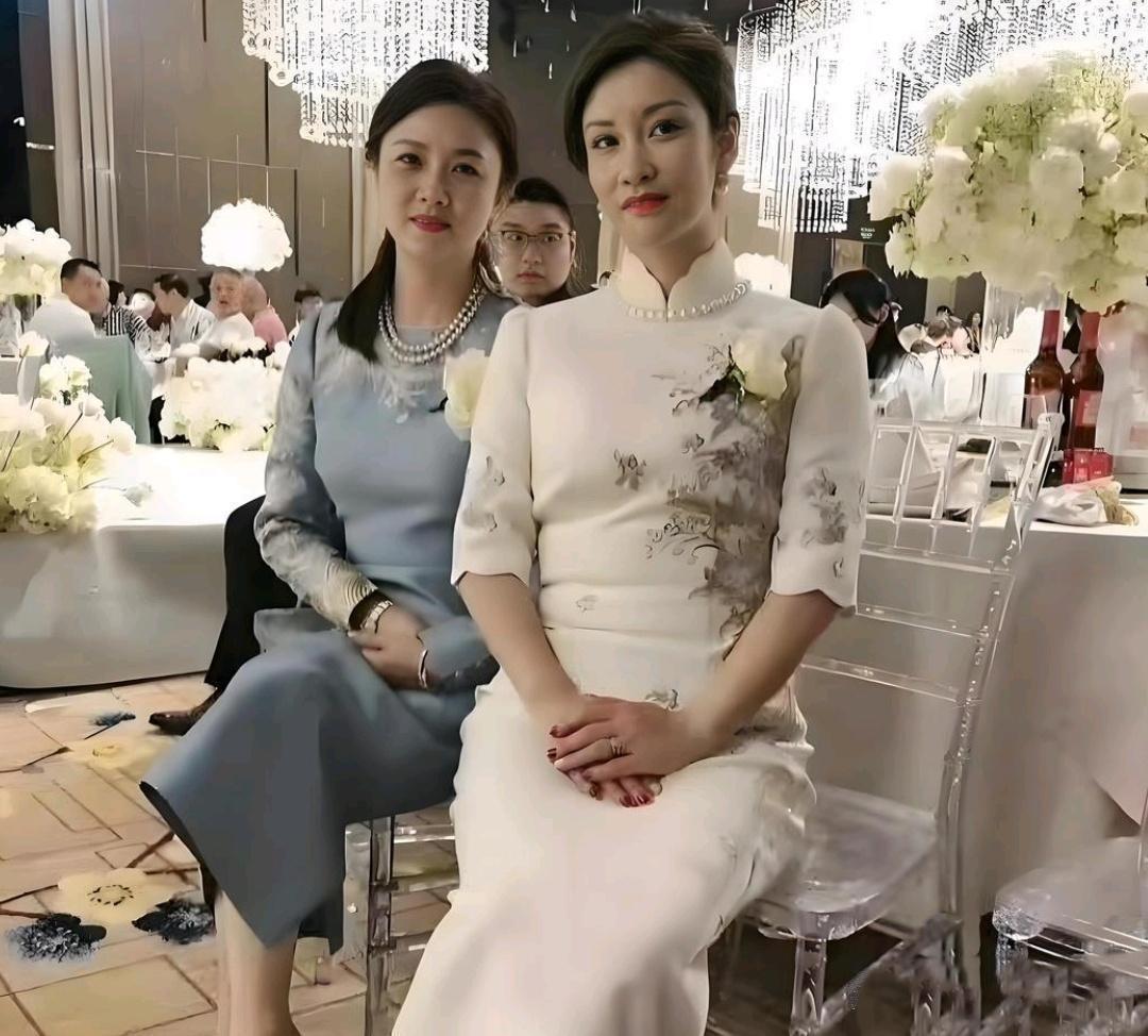 婚礼现场实拍，两位妈妈并肩而坐，一身雅致新中式礼服，气质温婉大方，一看就气度不凡