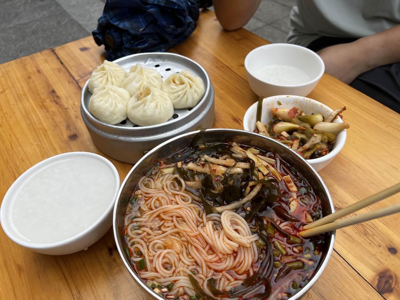 这就是我们两个人早晨的早餐，一笼包子一笼饺子，一碗鱼粉，大米粥免费吃各种小菜免费