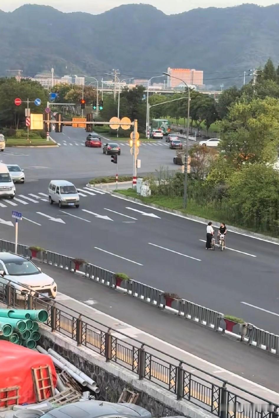 大娘就是大娘，在马路中间，随时随地自行车一跨就聊起来了真把马路当自己家客厅了，