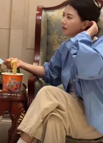 高圆圆机场等飞机，饿得吃泡面，不顾形象。工作人员拍下她叠腿、头发夹起的随意样，一