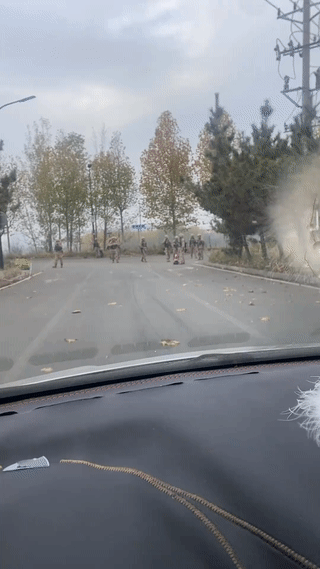 网友开车回家的路上在路口偶遇一群正在野外拉练训练的兵哥哥。他们看到有车过来都自