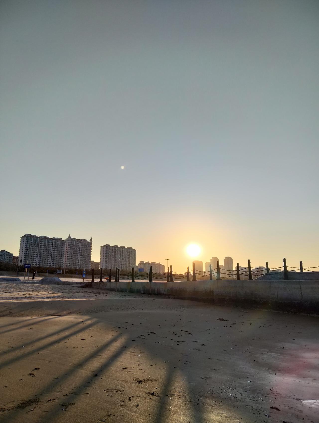 随手拍一张夕阳西下的美景站在金沙滩上，听着海浪哗哗的呼吸声，向西遥望。夕阳照耀在