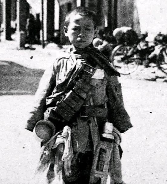 1938年10月，日本随军记者给15岁的俘虏小战士季万方拍照炫耀“战果”。不想