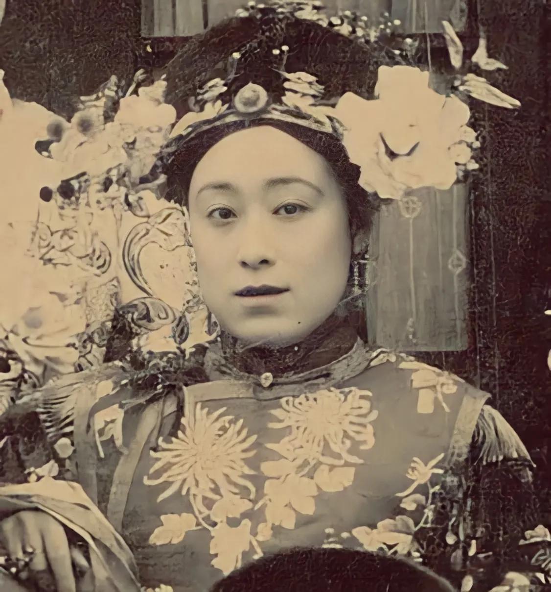 这张照片中的人物是裕德龄。她身着带有菊花纹饰的华贵服饰，头戴装饰繁复的旗头，妆容