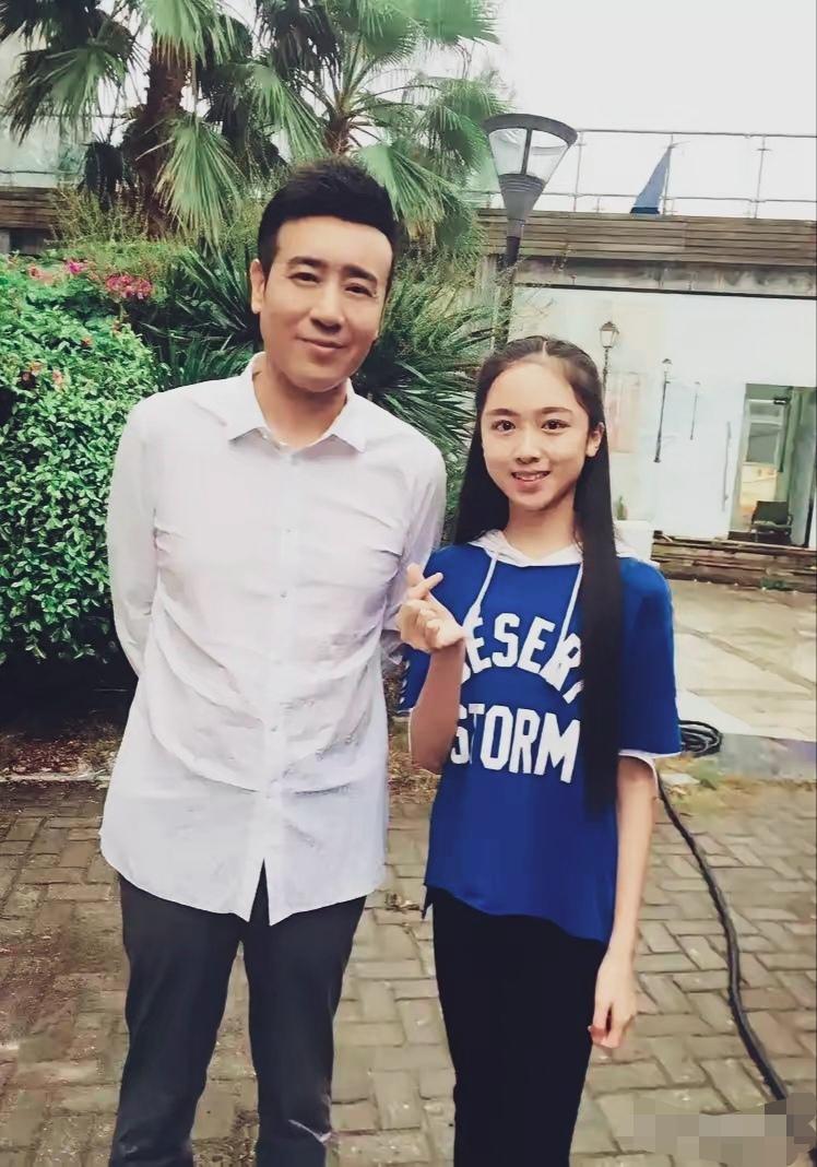 于和伟身着简约白衬衫+深色西裤，干净稳重；与粉色妹妹合影亲切随和。
