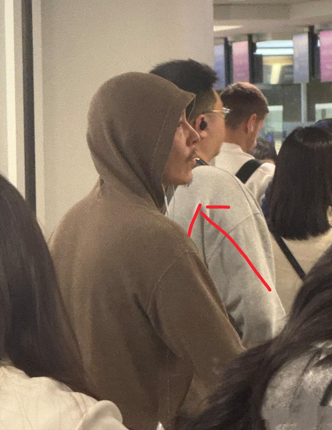 陈冠希在日本机场现身，他戴着棕色连衣衫上的帽子，一脸沧桑，胡子拉碴，眼神犀利，有