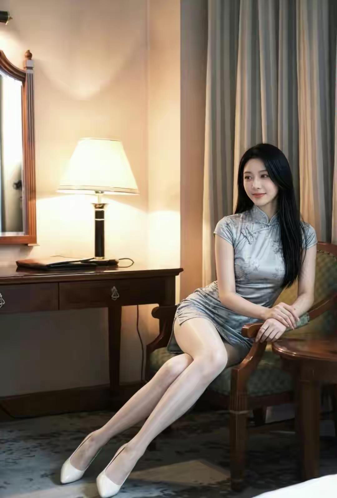 这位女士穿着旗袍坐在椅子上，美腿格外吸睛！