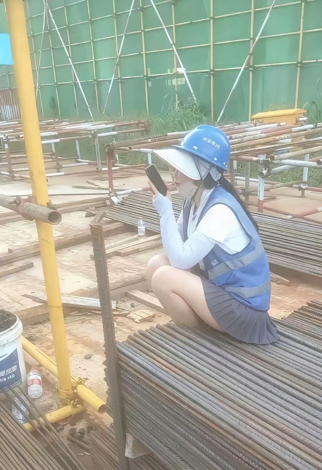 短裙配着遮阳帽，坐在钢筋上玩手机，工地上的这一幕，到底是真的还是假的？有人说