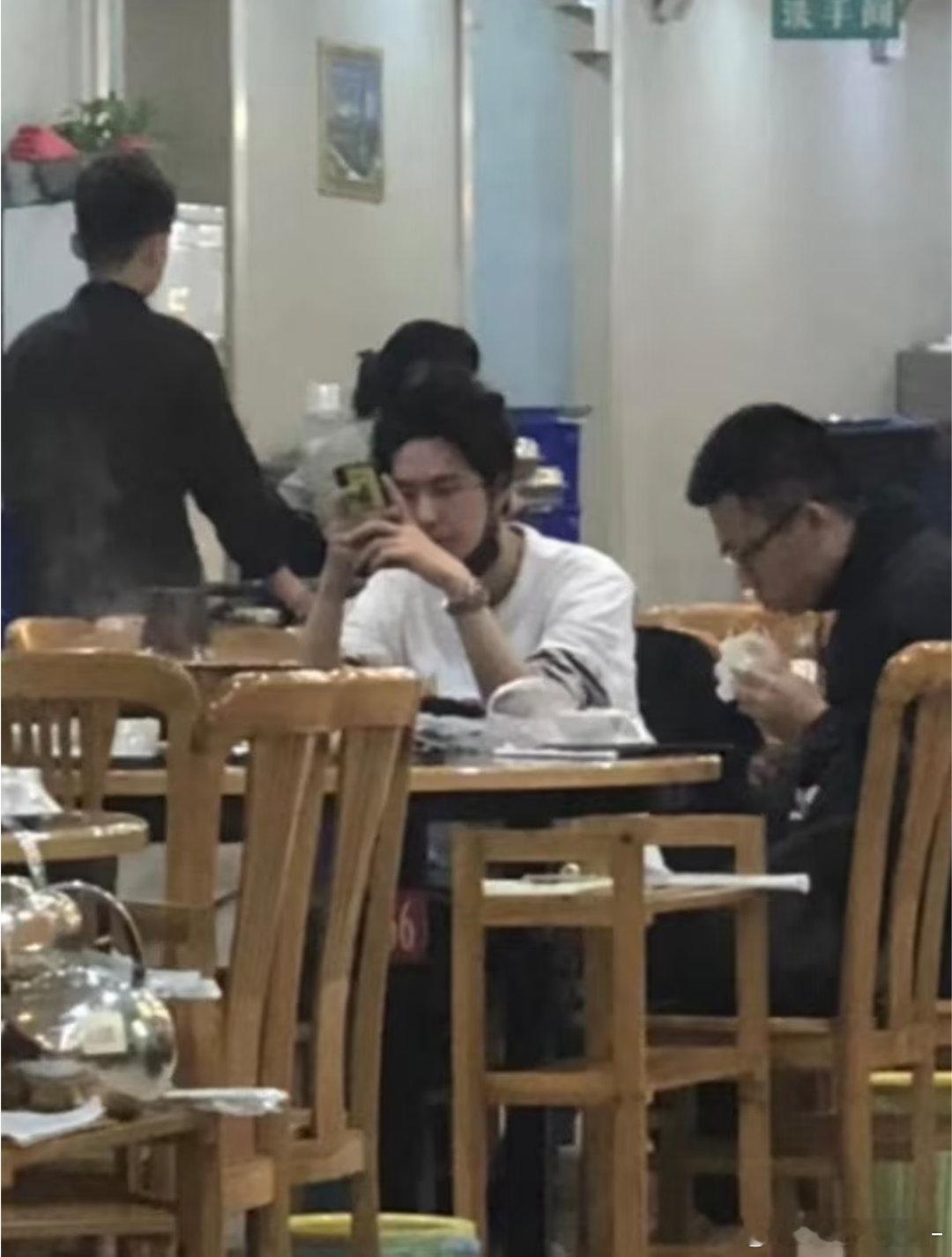 在等吃饭的王一博还戴了一副眼镜