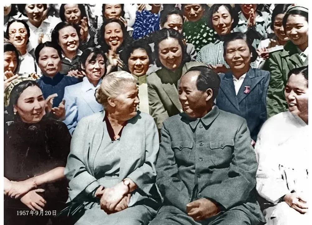 在一次重要会议上，现场气氛庄重而热烈。毛主席正与一位头发全白的老妇人笑容满面地交