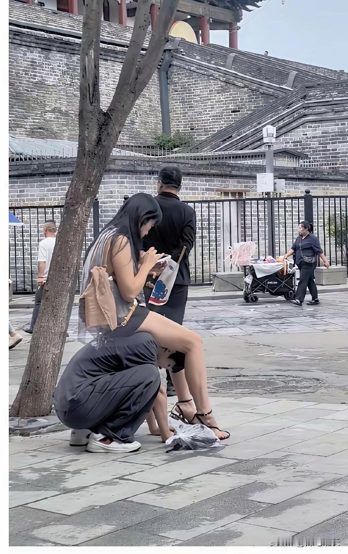 这张网络热图拍摄于景区，旁边明明有公共石凳，女子却直接坐在蹲下男子的背上，全程低
