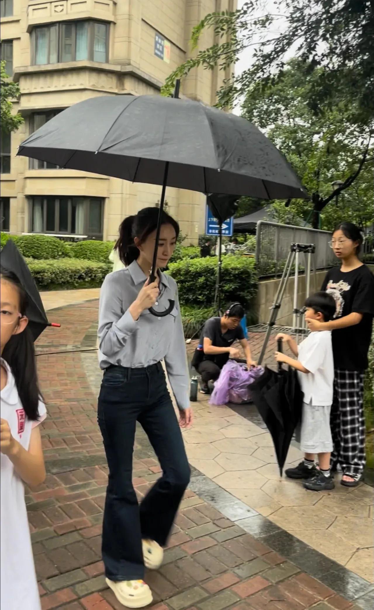 李小冉本人看着很瘦很高，脸巨小，腿超长，在人群中气质好出挑！一身简单的灰衬衫牛仔