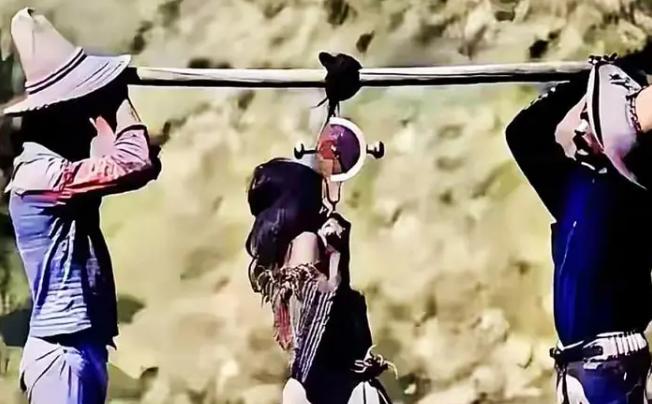 18世纪，两名白人男子用一根木棍抬着一名当地土著，画面中的女孩正被当成商品交易，