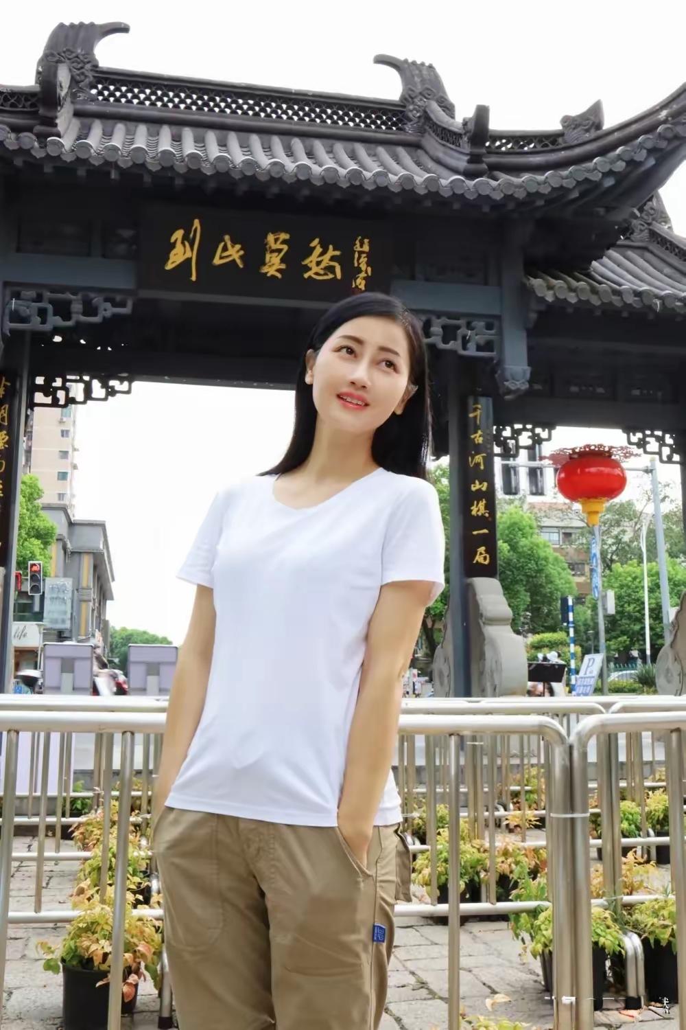 在古风牌楼前拍照打卡的美女。