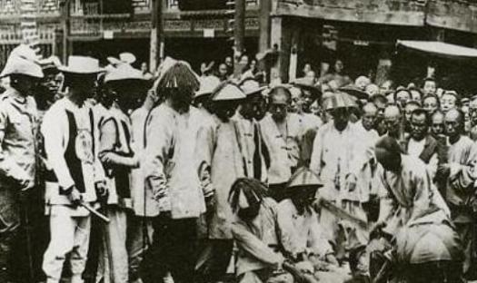 1855年，京城，小刀会一名女将被凌迟处死，她被五花大绑地捆在木桩上，衣服被扒光