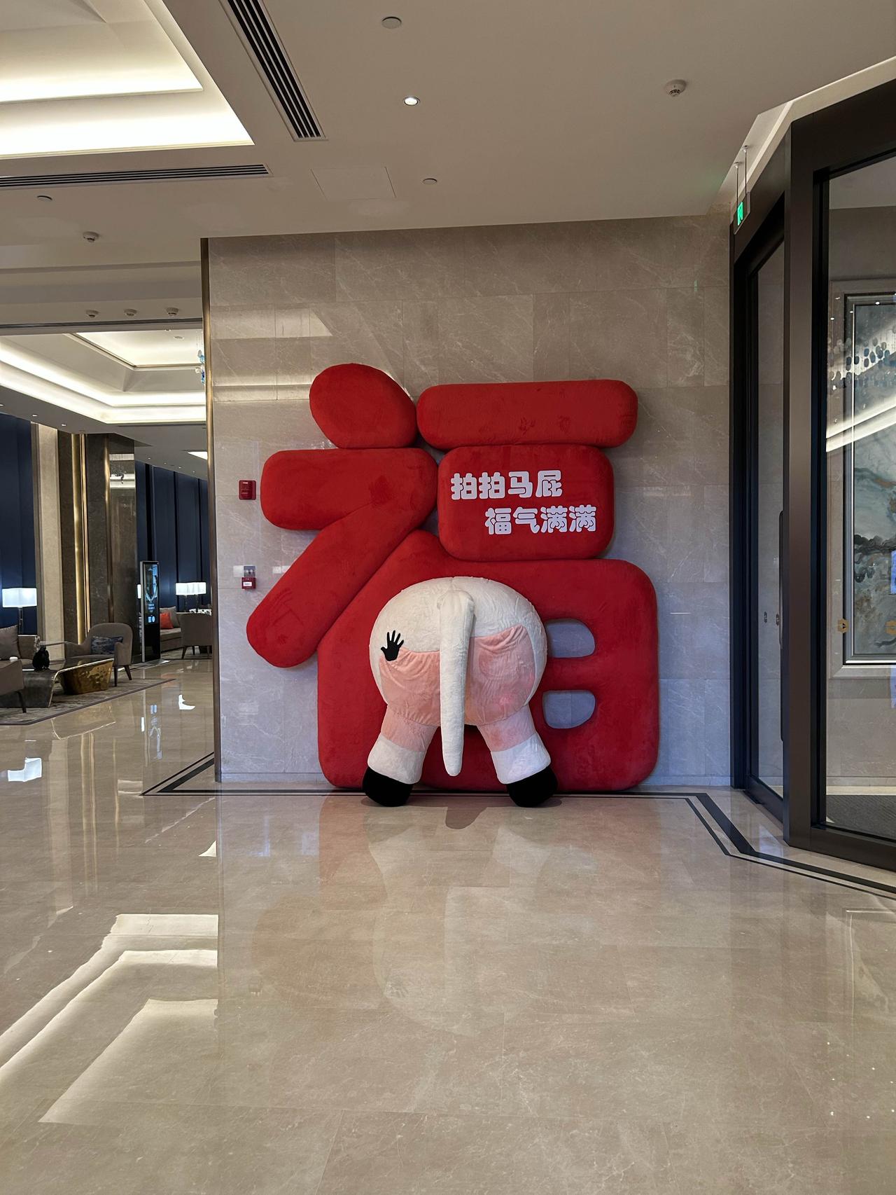 某五星级酒店进门的迎马年标语装饰还真是有不少人去拍了一下，福字背景下写了“拍拍马
