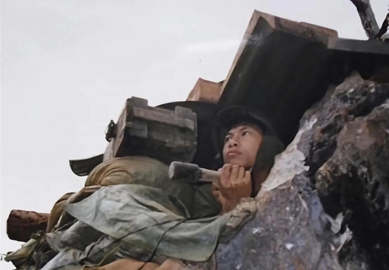 这张照片拍摄于1985年，照片中这名战士正坚守在146高地上，他手中拿着手榴弹，