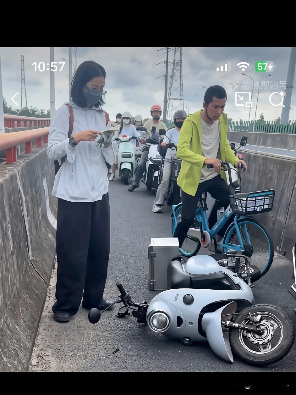 上海街头，一位骑电动车的姑娘追尾前方车辆后摔倒在地。前方男子立刻停车回头询问：&34;要不要报警？&