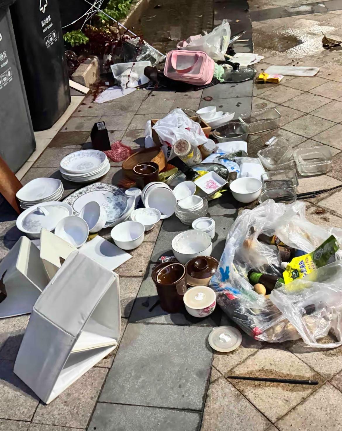 小区垃圾桶旁摊着半米宽的餐具阵，白瓷盘碗锃亮如新，连调料瓶都擦得干干净净。不用问