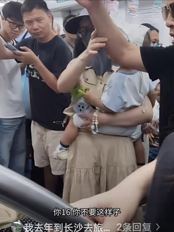 地铁让座引争议。地铁上，墨镜大爷看到身旁站着一位抱小孩的女子，便热心地建议坐在对