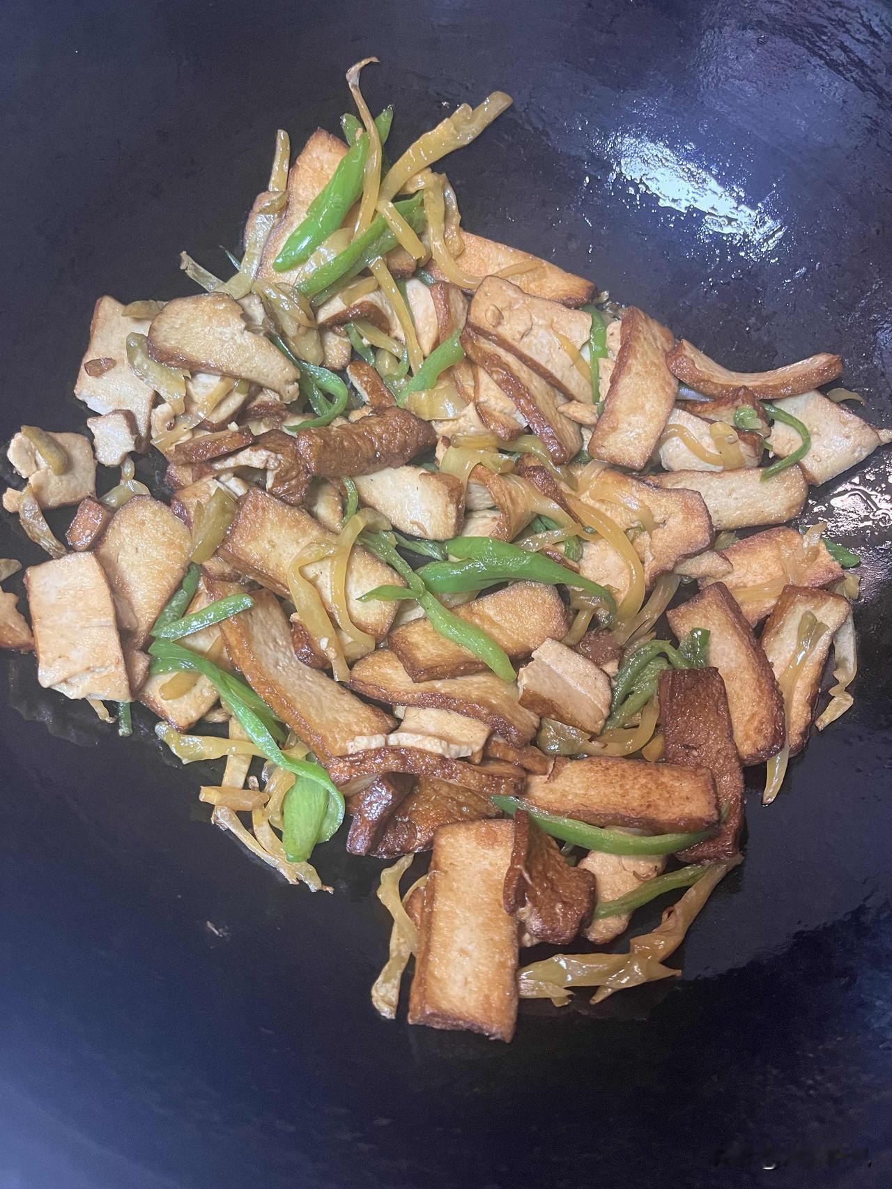 今天下班回家，给自己炒了盘香干榨菜青椒。用大铁锅把香干煎得两面金黄，再配点脆