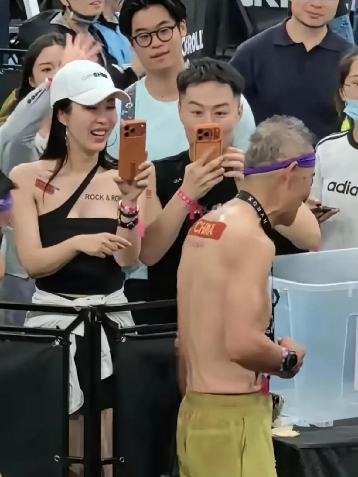 王石在赛道上拼体能，田朴珺在场边举手机，结果抢镜的，竟是旁边男子的橙色手机壳。一