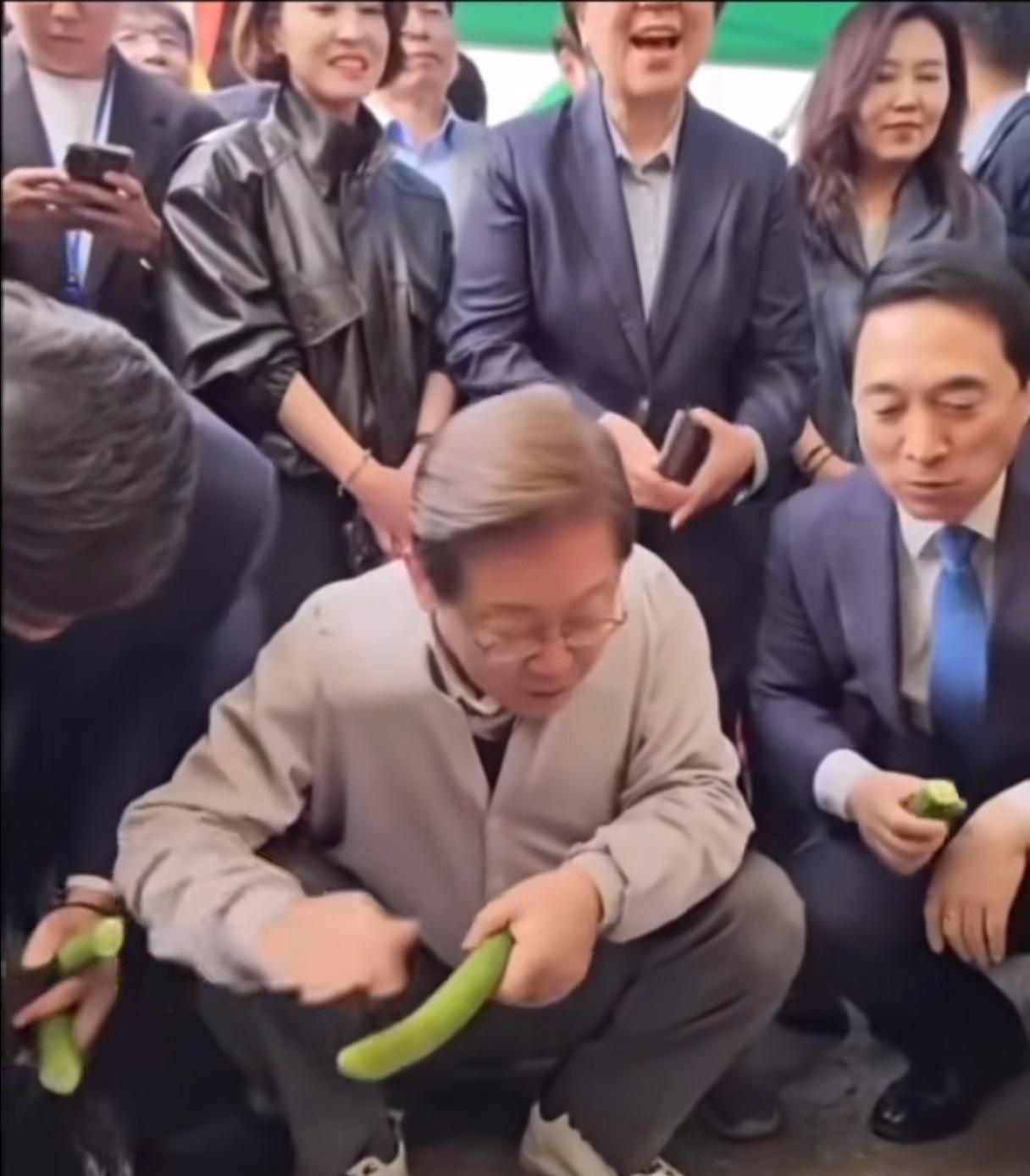 这样的总统，哪个不喜欢。文在寅，在卖菜的小摊位，蹲下，买了几根黄瓜。摊主给他装