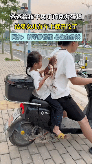 爸爸给娃买了巧克力蛋糕，本想着回家慢慢享用，结果娃坐在电动车后座上，迫不及待就开