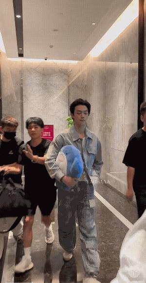 许凯上班啦！一身牛仔衣，白色运动鞋，青春男大呀，非常帅气！手里一直抱个蓝色玩具海