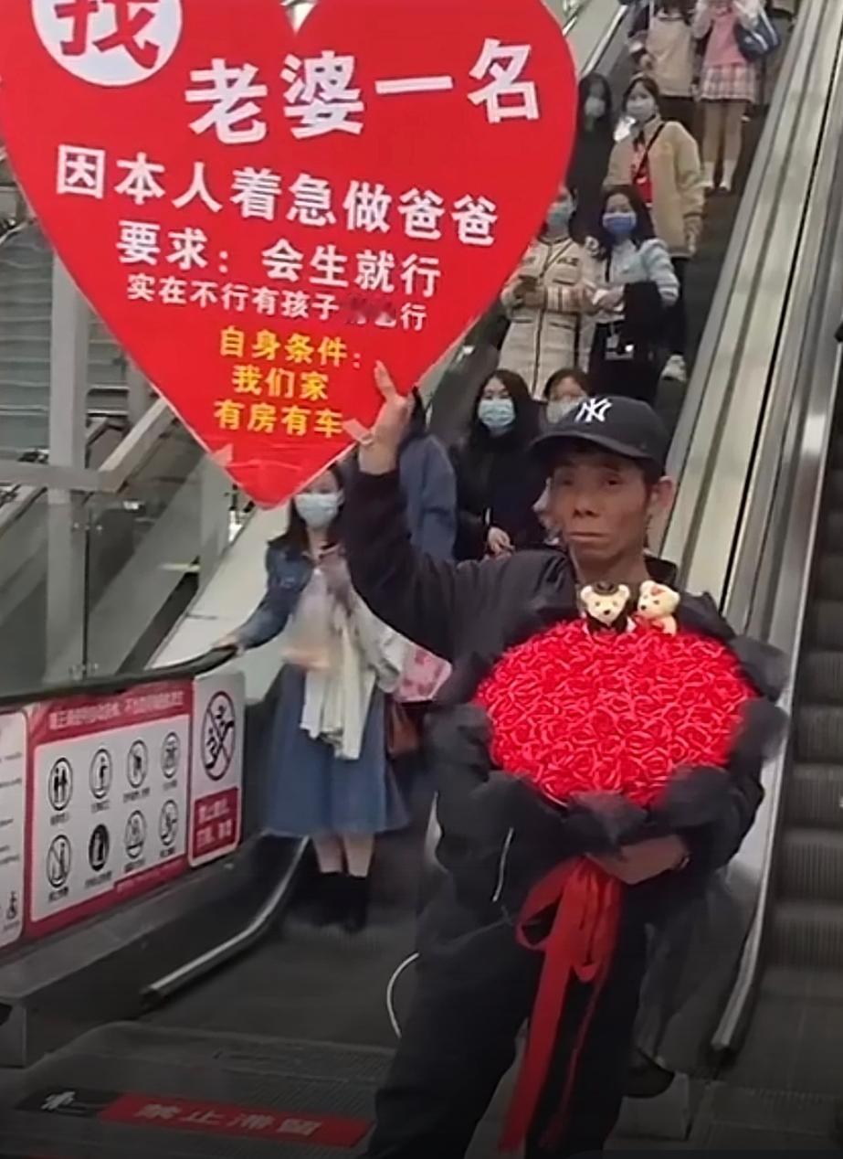 能看得出来，老哥是真急了！人来人往的电梯旁，他举着一块醒目的征婚牌，成了最扎